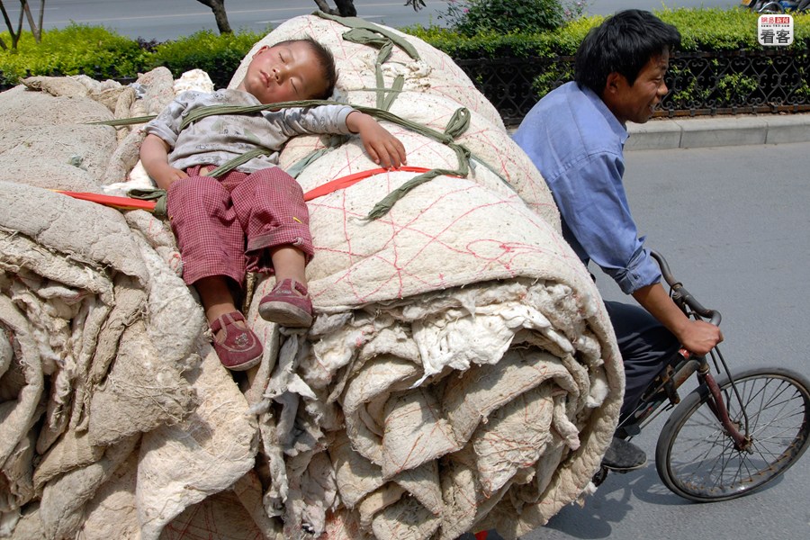 A child is sleeping on his father's  rickshaw