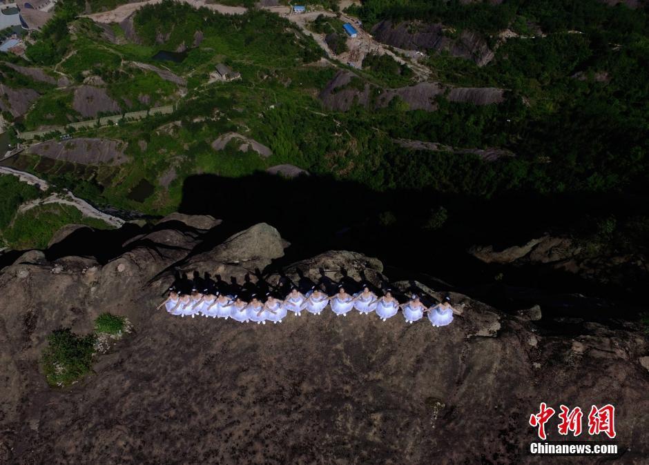 A group of ballet dancers pose on top of mountains in Pingjiang of Hunan
