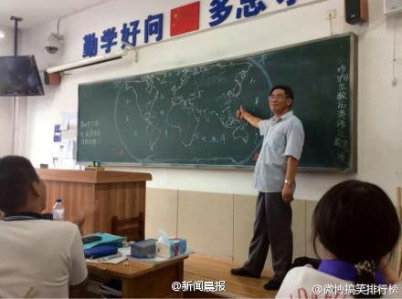 hand-drawing a world map on black board in classroom