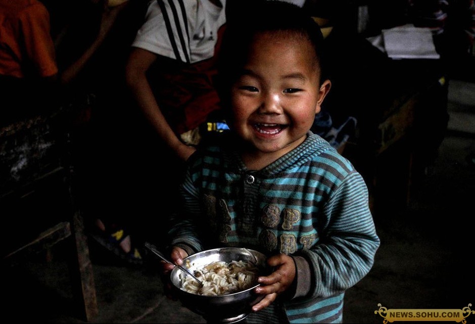 a chinese rural student is enjoying his lunch cooked by their teacher