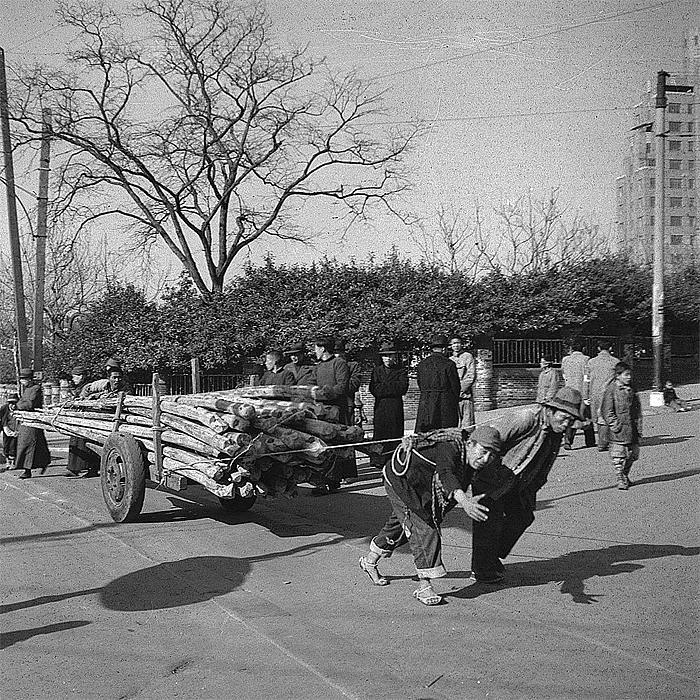 men pulling logs on street, old shanghai life